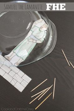 a glass bowl filled with matches next to a pile of clothes pins and some paper