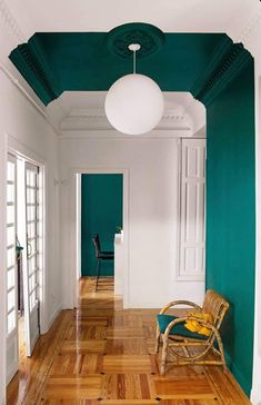 an empty room with green walls and wooden floors