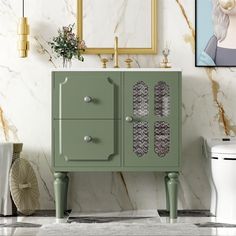 a bathroom with marble walls and flooring next to a green cabinet in front of a white toilet