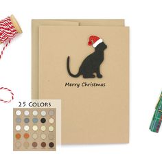 a christmas card with a cat on it next to some crafting supplies and scissors