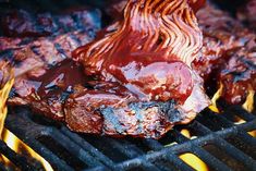 steaks being grilled on the grill with red sauce