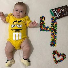 a baby laying on the ground next to a candy bar