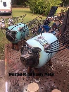 two pigs are sitting on the back of a metal cart with wires attached to it