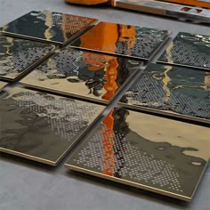 several pieces of metal with orange and black designs on them, sitting next to each other