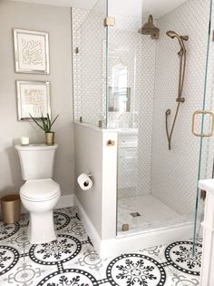 a white toilet sitting in a bathroom next to a walk in shower and tiled floor