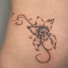 a tattoo on the side of a woman's stomach that has a flower in it