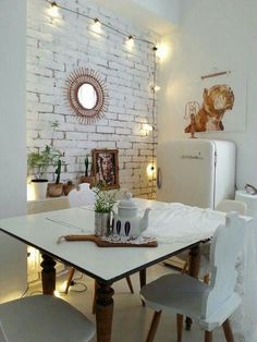 a white brick wall in the corner of a dining room with chairs and a table