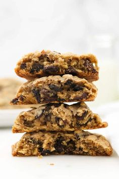 three oatmeal cookies stacked on top of each other in front of a glass of milk