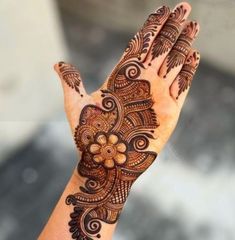 a woman's hand with henna tattoos on it