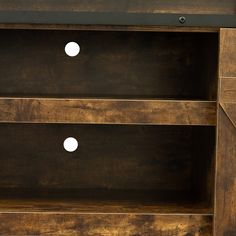 a wooden entertainment center with two drawers and three white knobs on the bottom shelf