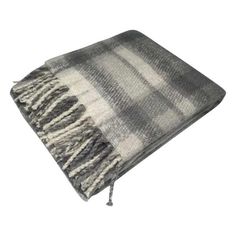 a gray and white blanket with fringes on it's end, laying down