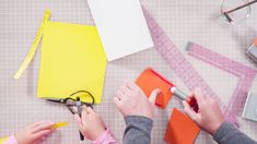 two people working on crafting with scissors and construction paper next to eachother