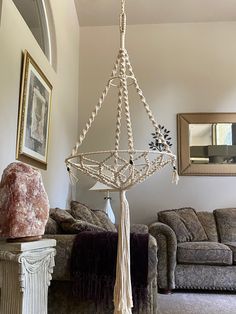 a chandelier hanging from the ceiling in a living room next to a couch