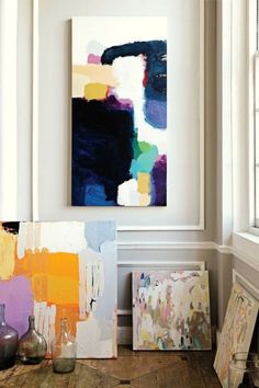 some paintings are sitting on the floor next to each other