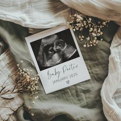 an image of a baby's photo on top of a blanket next to dried flowers