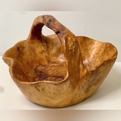 a wooden bowl sitting on top of a white table