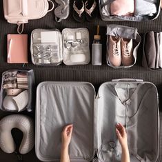 someone's feet resting on an open suitcase next to other luggage and accessories,