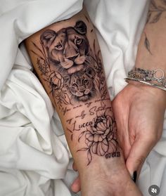 a woman with a tattoo on her arm holding onto a cat and flowered bracelet