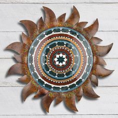 a decorative wooden sunflower on a white wood wall with an orange and green circle in the center