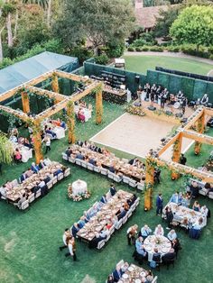 an aerial view of a wedding reception with tables and chairs set up in the grass