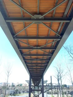 the underside of a covered walkway with trees in the background