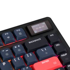 a black and red computer keyboard with an alarm clock on the back side, against a white background