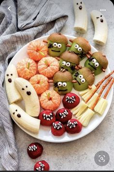 a white plate topped with fruits and veggies covered in googly eye eyes