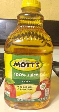 a bottle of mott's juice sitting on top of a stove