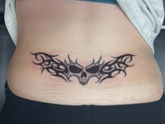 a woman's stomach with a tattoo design on the lower part of her belly