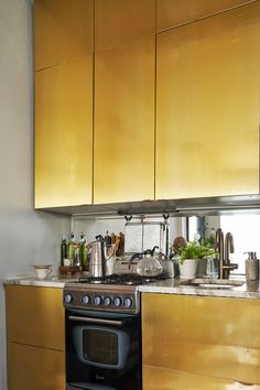 a stove top oven sitting inside of a kitchen next to wooden cupboards and counter tops