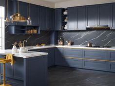 a large kitchen with blue cabinets and marble counter tops, gold accents on the counters