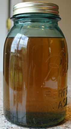 a glass jar filled with liquid sitting on top of a counter