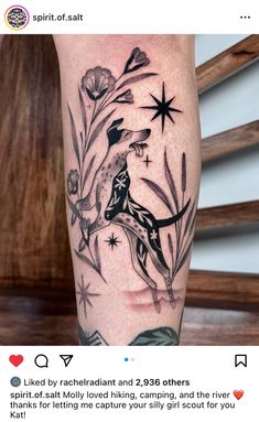 a person with a tattoo on their leg that has flowers and stars in the background