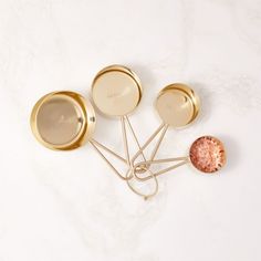 three golden dishes on a white marble surface