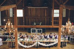 a group of people sitting around a table in a room with chandeliers on it