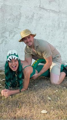 a man and woman dressed in costumes pose for a photo together on the grass with one another