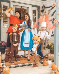 a group of people in costumes standing on the front steps of a house with pumpkins