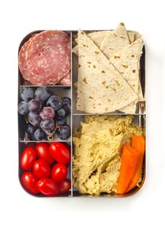 a bento box filled with different types of food and fruit on top of it