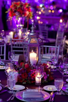 a table set with plates, silverware and candles