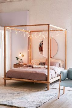 a bedroom with a bed, mirror and lights on the wall above it's headboard