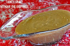 a glass bowl filled with brown liquid on top of a red table