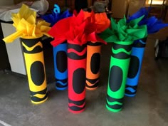 three colorful vases with paper flowers in them