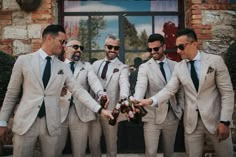 a group of men in suits and ties holding each other's hands