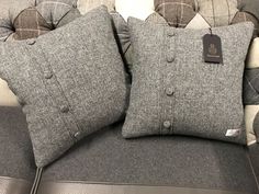 two gray pillows sitting on top of a couch