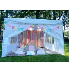 a white tent with colorful curtains and pillows