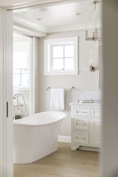 a white bathroom with a tub and sink