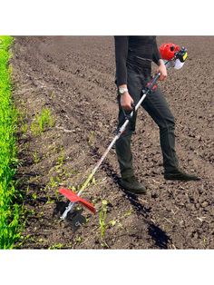 a man is walking in the middle of a field with an electric tiller on it