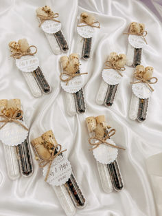 small glass bottles with corks tied in twine on a white satin covered table cloth