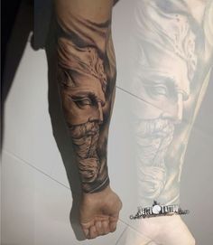 a man's arm and leg covered in tattoos with an image of two men