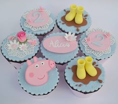 cupcakes decorated with pink and blue frosting are arranged in the shape of farm animals